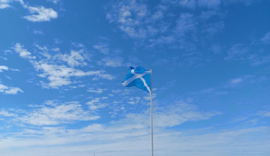 A saltire flag against a blue sky.