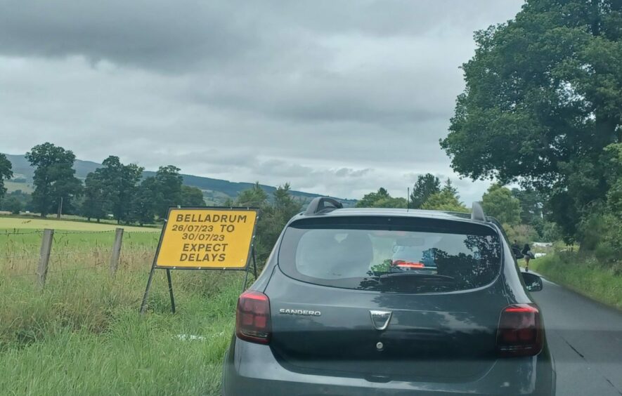 Sign on road towards Belladrum Festival 2023 warning motorists to expect delays.