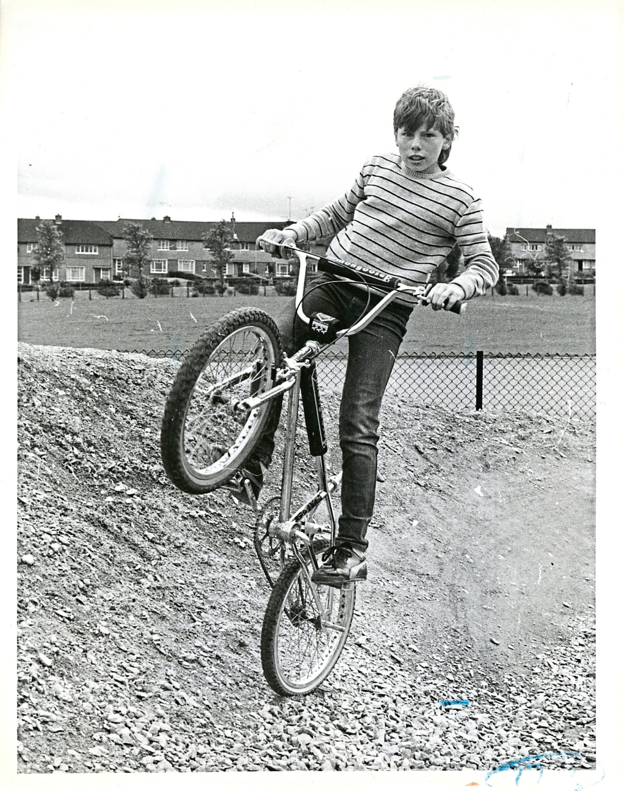 A young boy performing tricks on his BMX