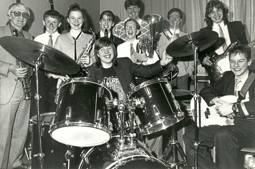 A pupil jazz band with their instruments gathered around a drum kit