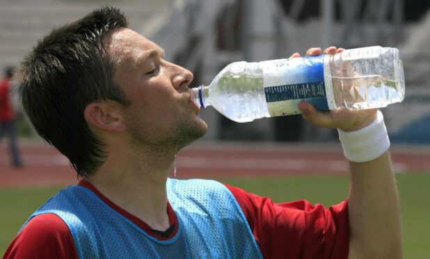 Aberdeen midfielder Barry Nicholson takes a break in the heat of Alexandria in 2007. Image: Newsline