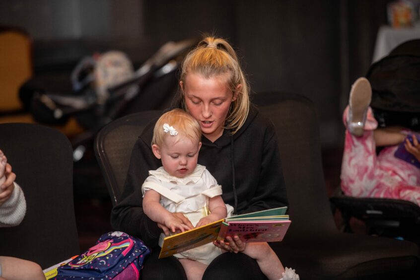 Mum reading to her child at the Peterhead Scottish Week Baby Show.