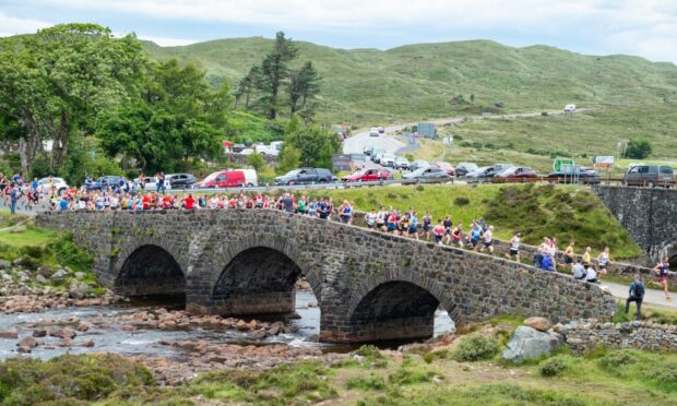 Runners make their way over the old bridge in Sligachan at the start of the Glamaig Hill Race. Image: Simon Riddell