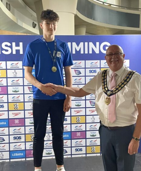 Dean collecting a gold medal at the Speedo British Summer Championships 2022 in Sheffield.