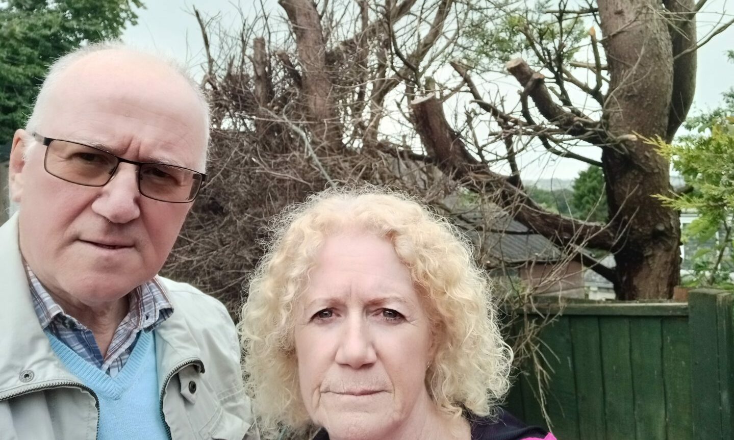 Alistair and Susan Robb stand in front of the damaged trees.