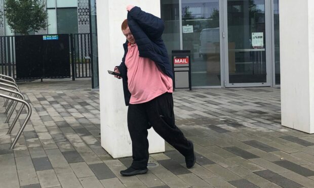 Brian Farmer covered his face as he left Inverness Sheriff Court