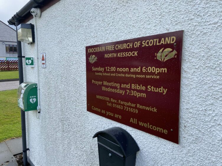 Sign outside Knockbain Free Church of Scotland still lists Farquhar Renwich as minister.