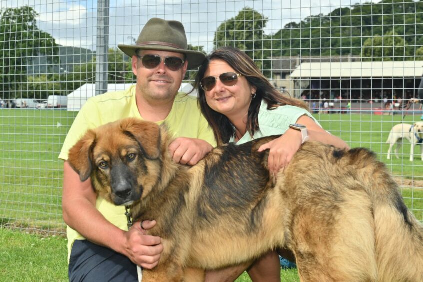 Man and woman at the event with their dog.