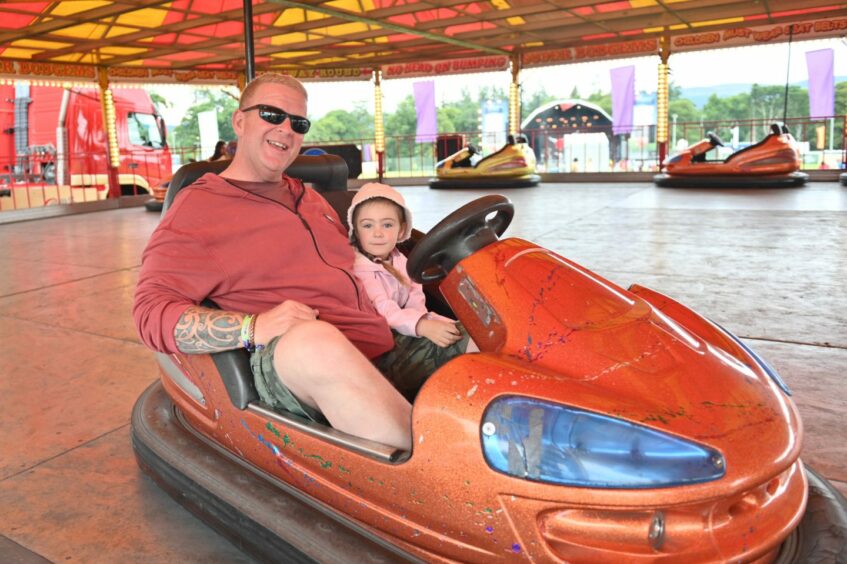 Man on bumper car with granddaughter.
