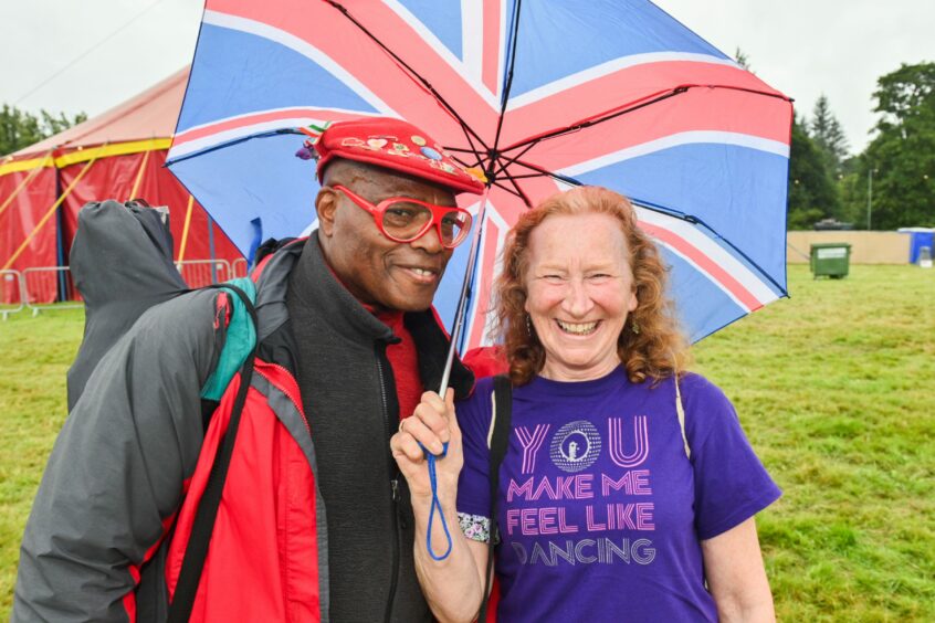 Two revellers under a Union Jack umbrella.