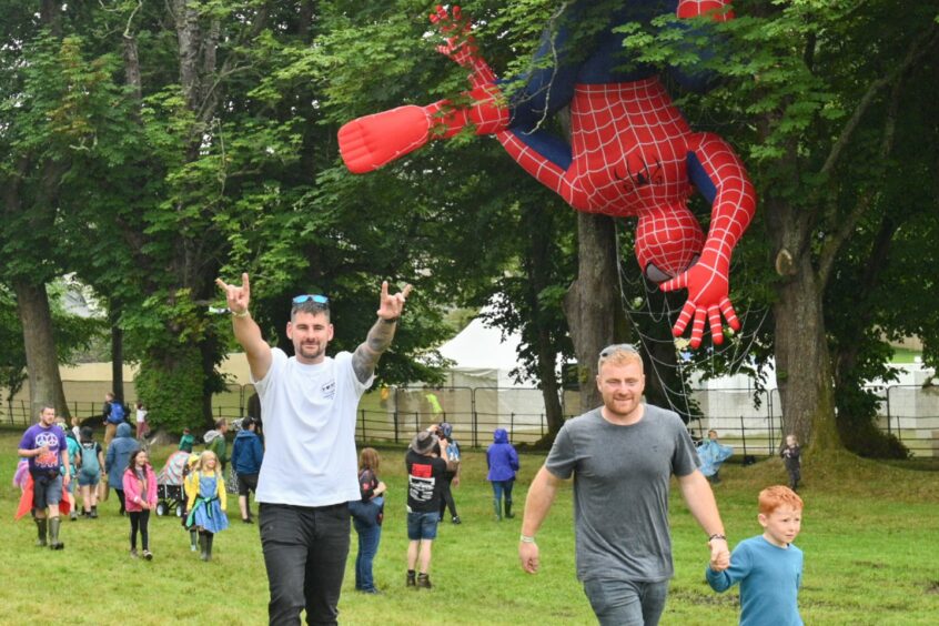 Crowds of people gathered around giant Spiderman at Belladrum 2023.