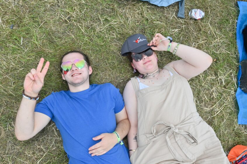 Young revellers lying in the grass.