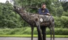 Sculptor Juha Saraste standing behind his metal deer creation.