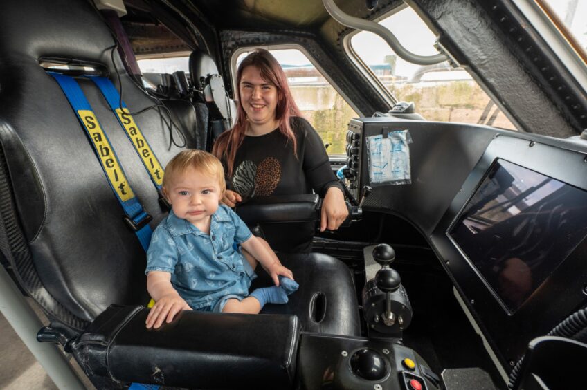Toddler sitting in Search and Rescue van's front seat.