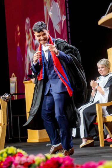 Graduate dances on stage as he graduates from RGU.