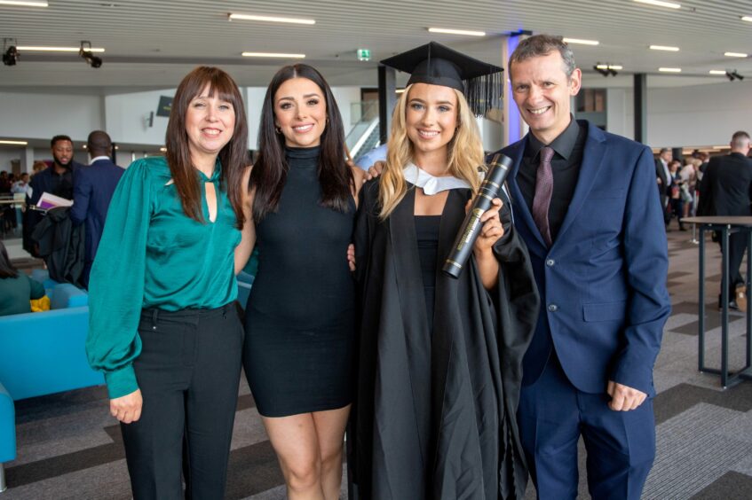 Graduate poses with her delighted family.