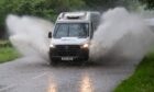 A van splashing through a large pool of water on the road. Heavy rain has been forecast across Aberdeenshire, Argyll and the South Highlands.
