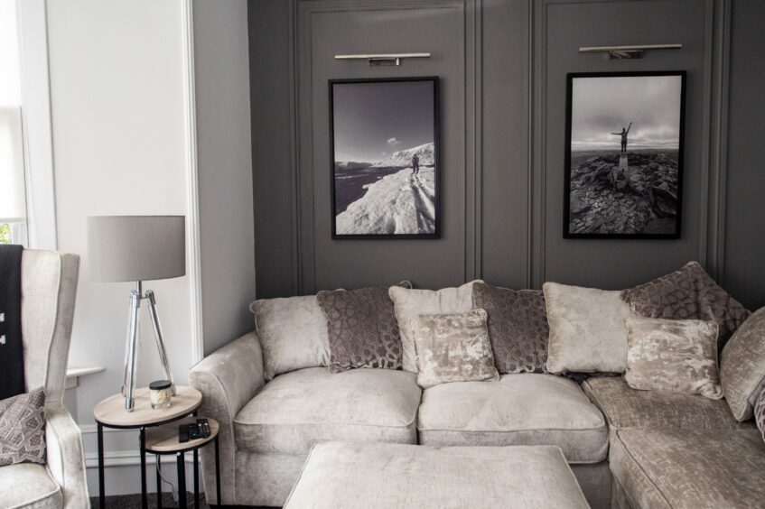 Another view of the living room featuring charcoal grey walls with French panelling. 