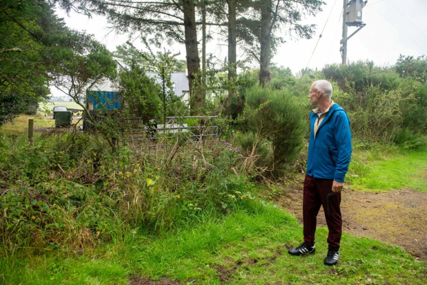  A longtime resident nearby, Richard McGhee, said his family has lived in the area for generations and said the public should have right of access to the road. Image shows Richard McGhee on the old drovers road where branches have been dumped to make access more difficult.