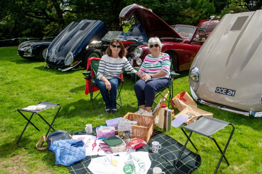 Two attendees enjoying a picnic at the Drum Castle car show.