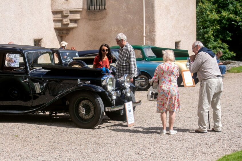 Event-goers looking at a classic car.