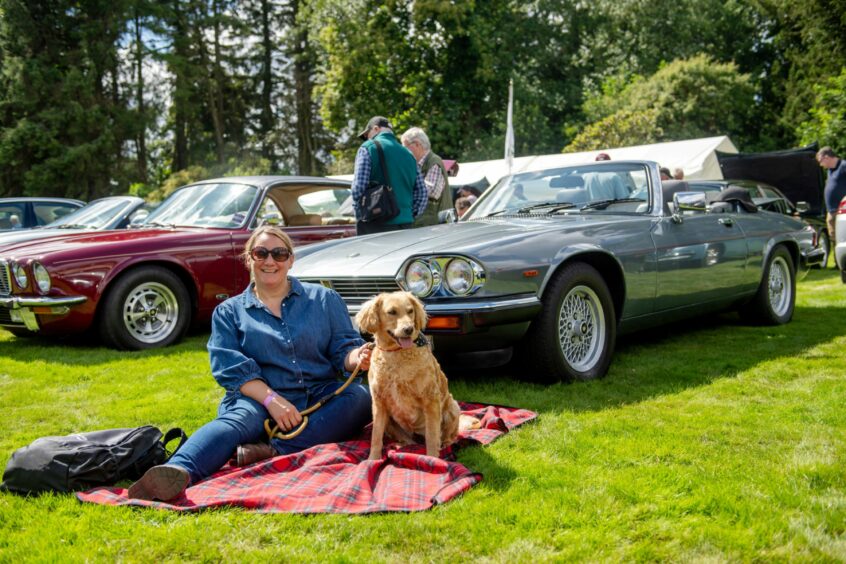 Woman with dog in front of a Jaguar XJS.