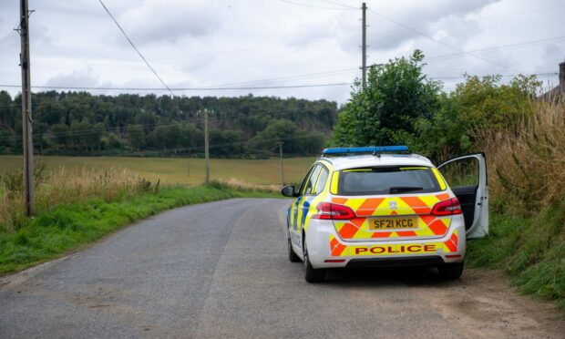 A police car sits on the roadside of a remote road in Inverurie.