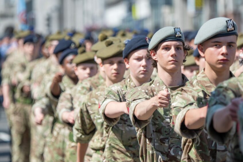 Army personnel marching in full uniform.