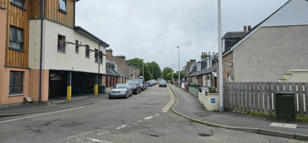 Property with windows open and road with cars.