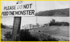 A picture of Loch Ness with a sign at the edge saying Please Do Not Feed The Monster