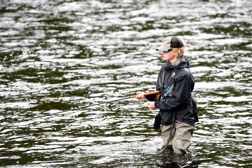 Will Hayden of Nairn stands knee deep in the River Spey as he enjoys a day of fishing. 