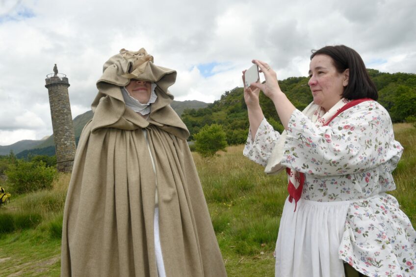 A woman recording the model in the Bonnie Prince Charlie Betty Burke disguise