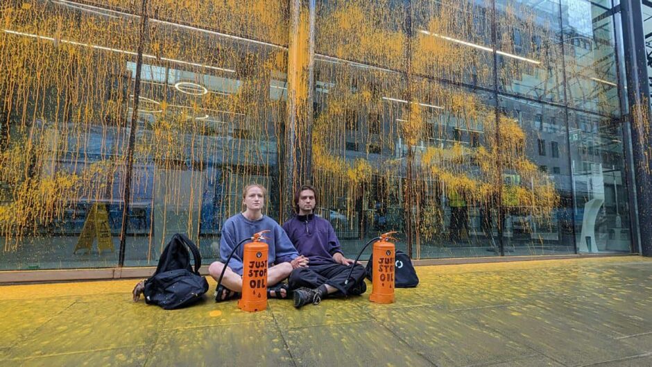 Just Stop Oil protesters Matthew Cunningham, 25, and Imogen May, 24, outside he Department for Energy Security and Net Zero in central London after covering the building in orange paint.