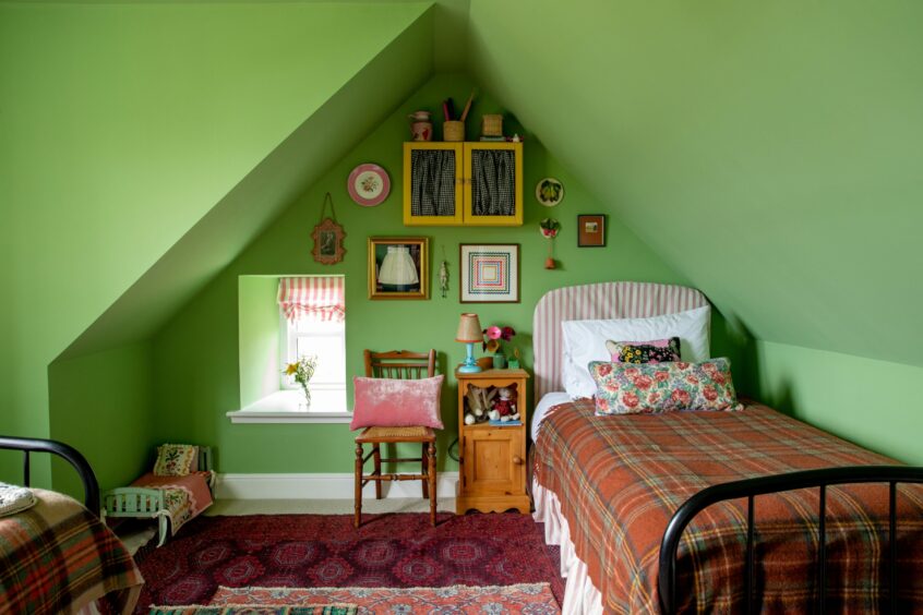 Another bedroom in the Banchory cottage with green walls and rustic decor.