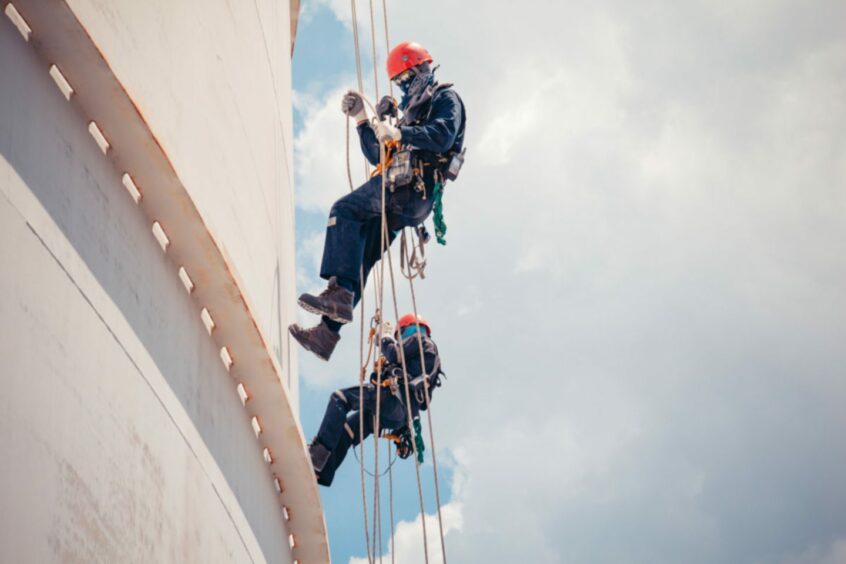 Workers climbing wind turbine.