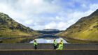 Three SSE Renewables employees in high vis coats stood in front of Sloy Power Station.