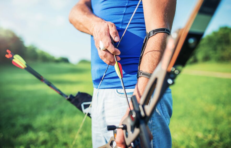 A stock image of a man holding a bow and arrow
