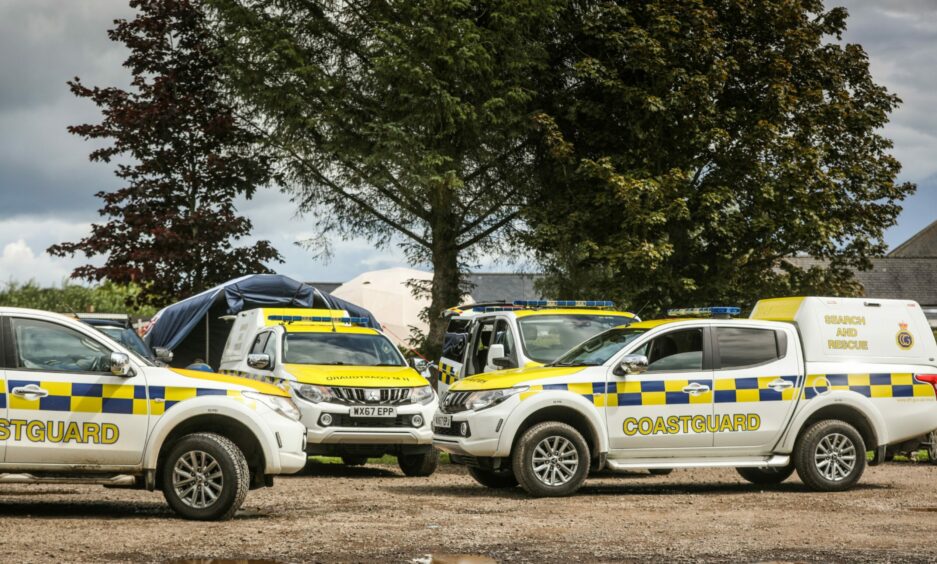Three white and yellow coastguard vans parked at the command centre in Edzell