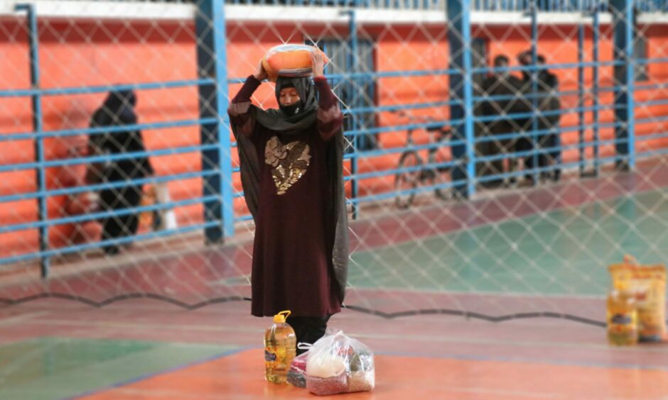 An Afghan woman collecting a food parcel from The Linda Norgrove Foundation.