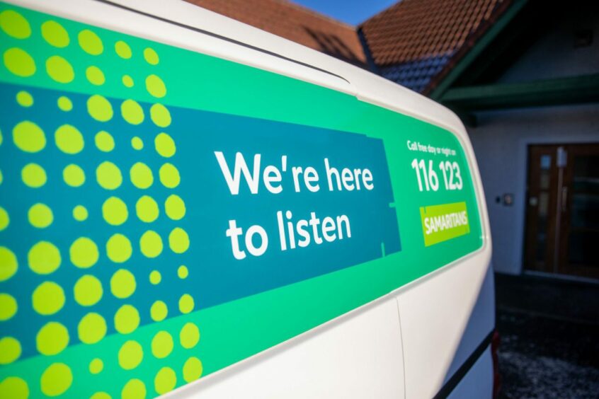 graphic on the side of a van advertising Samaritans' services reads 'We're here to listen' 