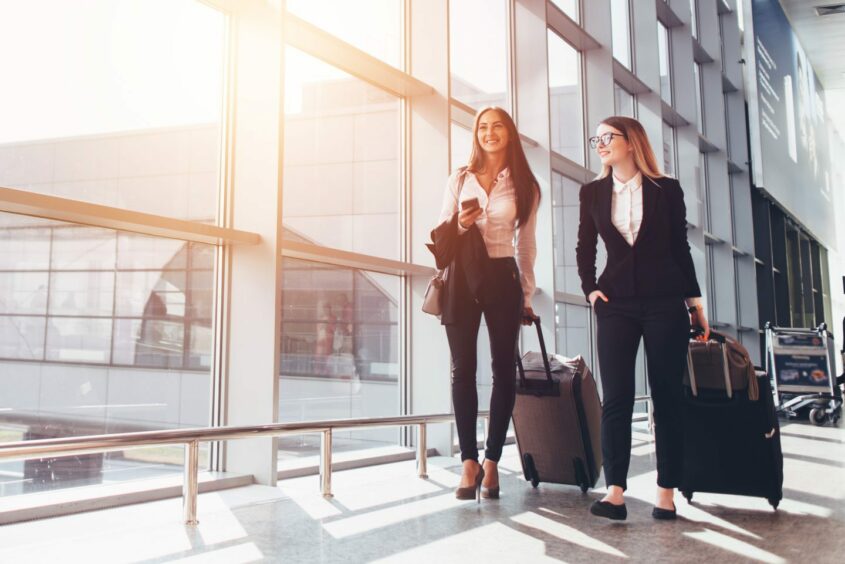 Businesswomen carrying suitcases.
