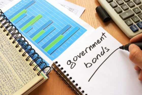 notepad saying government bonds next to a paper showing graphs.