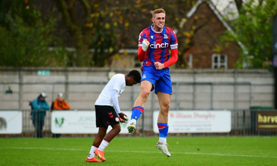 Killian Phillips celebrating in mid-air while playing for Crystal Palace