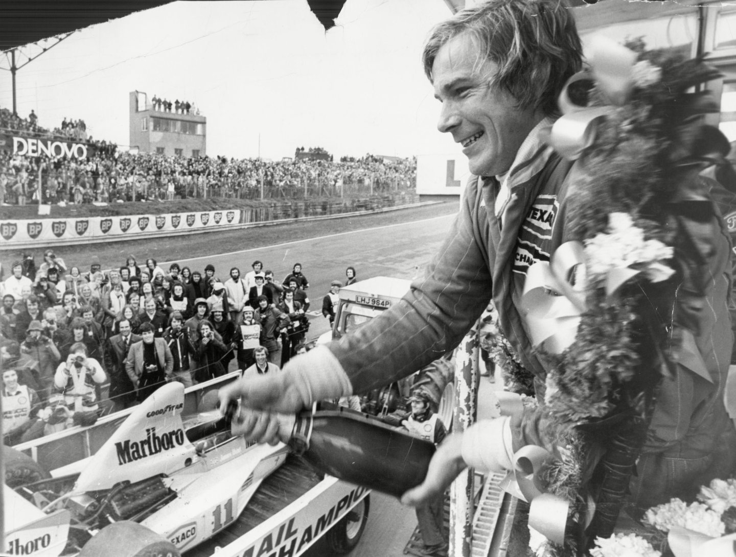 James Hunt opening a bottle of champagne on the podium
