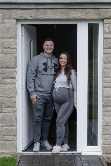Mike Scotland and his partner Nicola stand in the doorway of their new home at Southbank by Cala in Aberdeen.