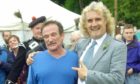 Billy Connolly embraces fellow comedian Robin Williams after he ran the hill race at the Lonach Games in 2002. Image: PA