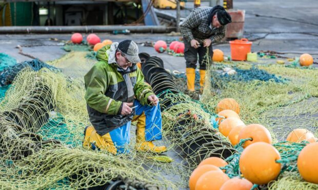 Fishers working on their nets in Peterhead. Peterhead.
