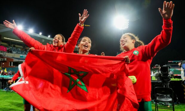 Morocco players wave their flag celebrating after qualifying into the round of 16 at the Women's World Cup