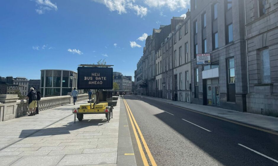 Temporary road sign warning drivers of new bus gates in Aberdeen city centre.