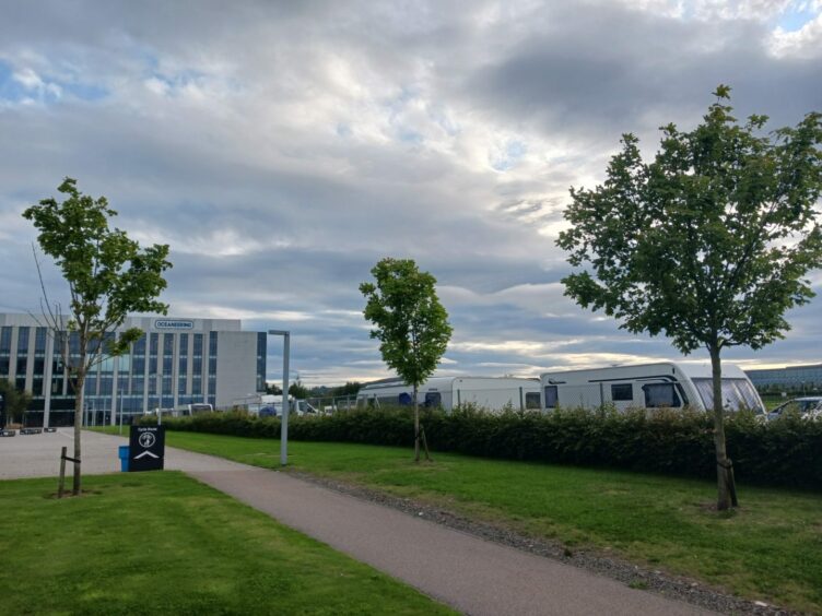 Travellers parked up with building in background.